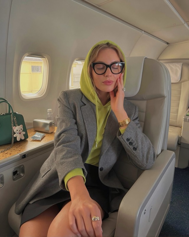 Ruby, reclined in a first-class cabin, glasses
